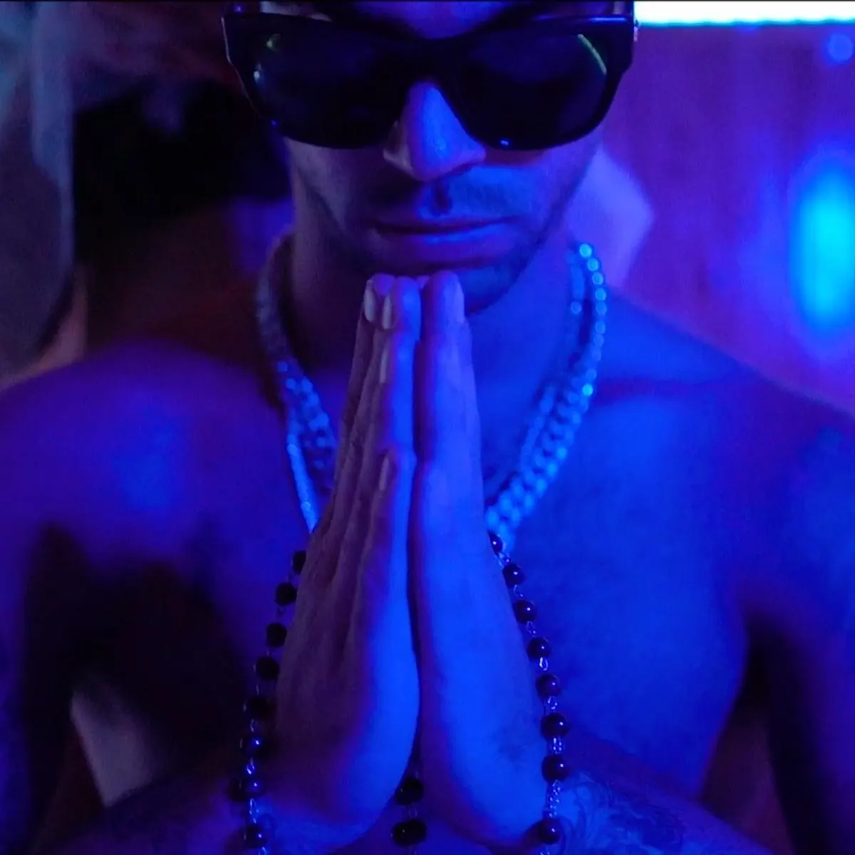Hands pressed together in blue light