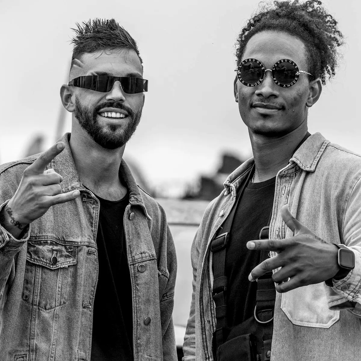 Two artists in denim jackets and sunglasses
