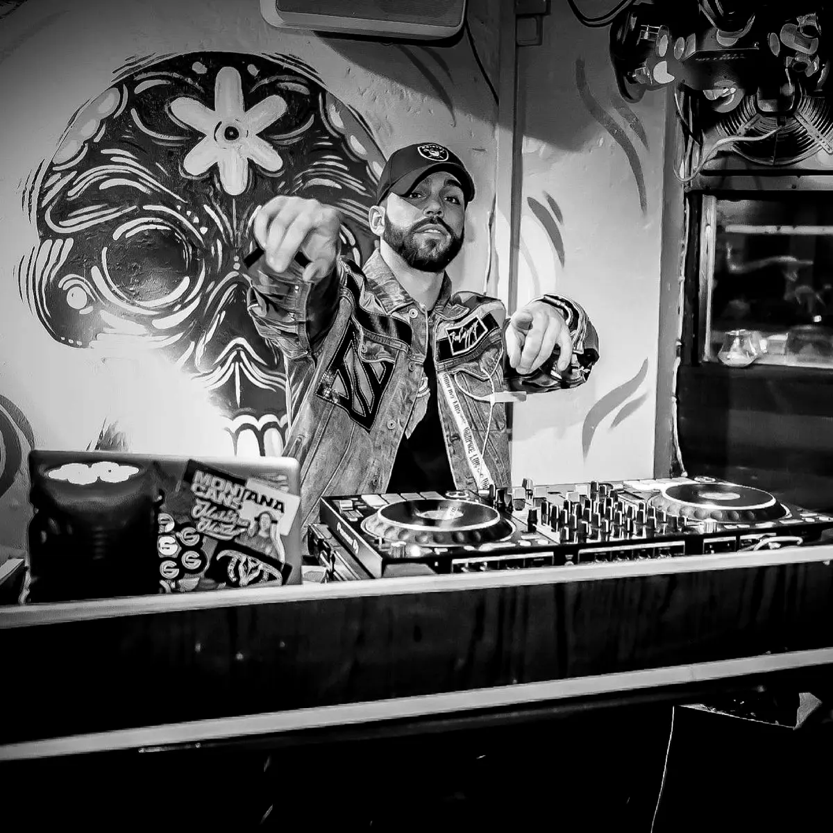 DJ playing in front of a painted skull mural