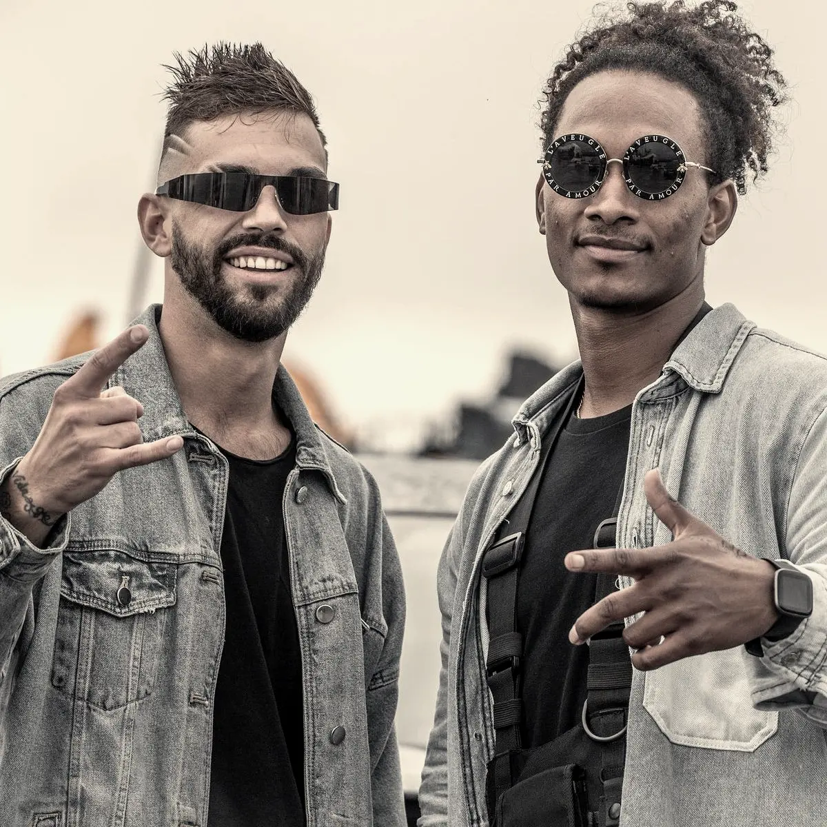 Two artists in denim jackets and sunglasses