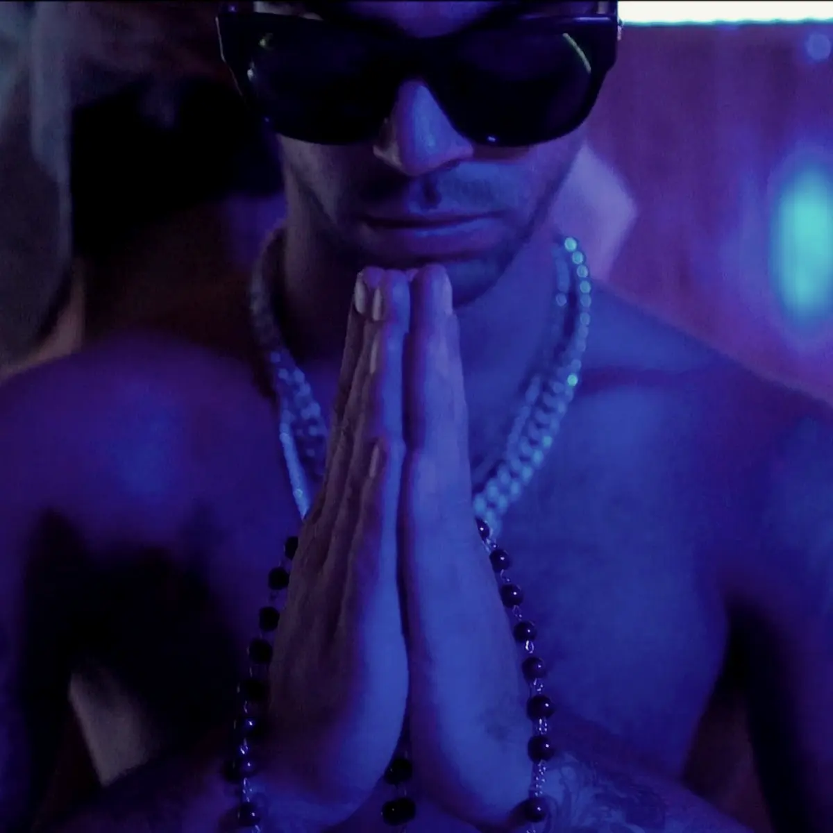 Hands pressed together in blue light